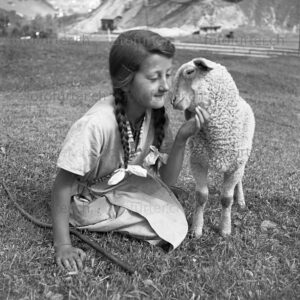 Mädchen streichelt kleines Lamm in Graubünden, fotografiert von Otto Furter