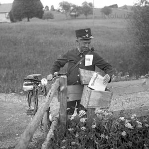 Postbote mit Fahrrad legt die Appenzeller Zeitung in den holzigen Briefkasten, fotografiert von Otto Furter